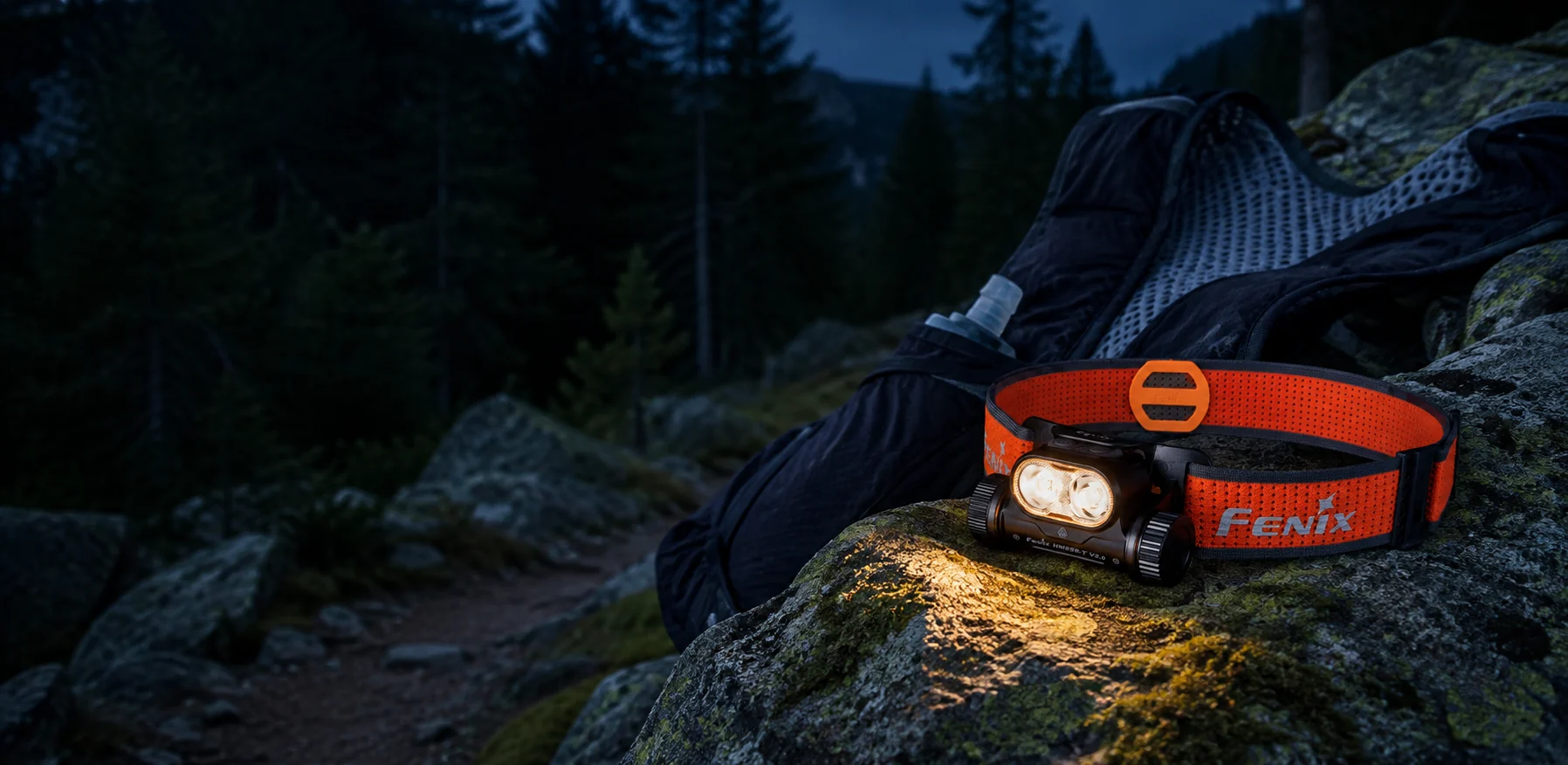 HM65R-T V2 resting on a mossy boulder beside a trail vest